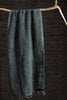 Dark green fabric draped over a wooden stick against a dark background