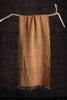 Brown woven fabric draped over a branch against a dark background